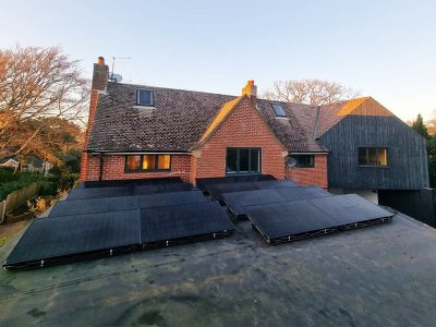 solar panels on flat roof in front of house